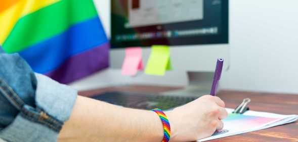 Woman's hand working in office with LGBT decor and accessories. Cultura LGBTQIA