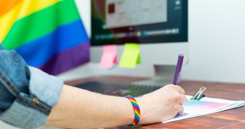 Woman's hand working in office with LGBT decor and accessories. Cultura LGBTQIA