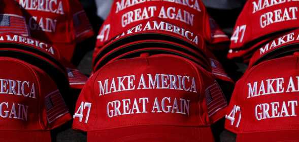 "Make America Great Again" hats sit on a table during a campaign rally for former US President and Republican presidential candidate Donald Trump.