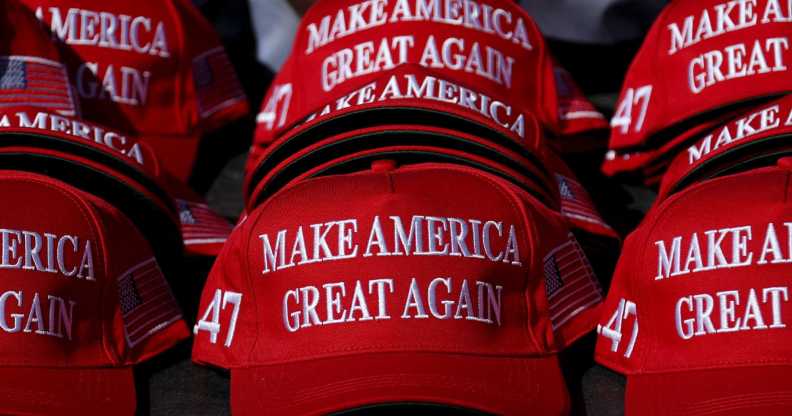 "Make America Great Again" hats sit on a table during a campaign rally for former US President and Republican presidential candidate Donald Trump.