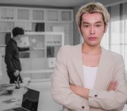 Portrait of young Asian people Non-Binary person standing with arms crossed and colleagues working together in background while discussing on new project at modern office, Corporate business meeting and Successful partners teamwork, Employees engagement and white-collar worker, Finance and Economy, Global Business and Strategy, Looking at camera