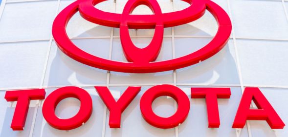 This is an image of a Toyota dealership sign. The lettering and logo is in red.