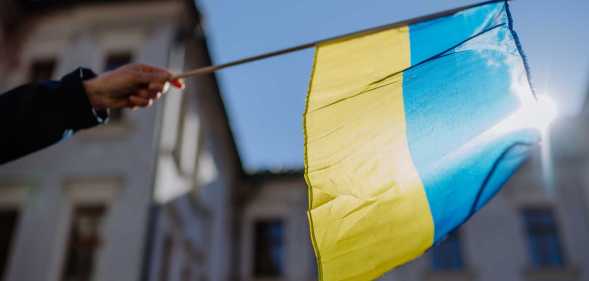 A person holds a Ukrainian flag in a protest against war.