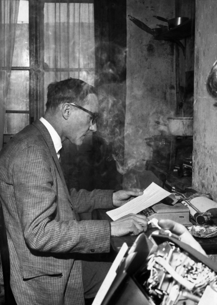 William S. Burroughs at a Typewriter while smoking.