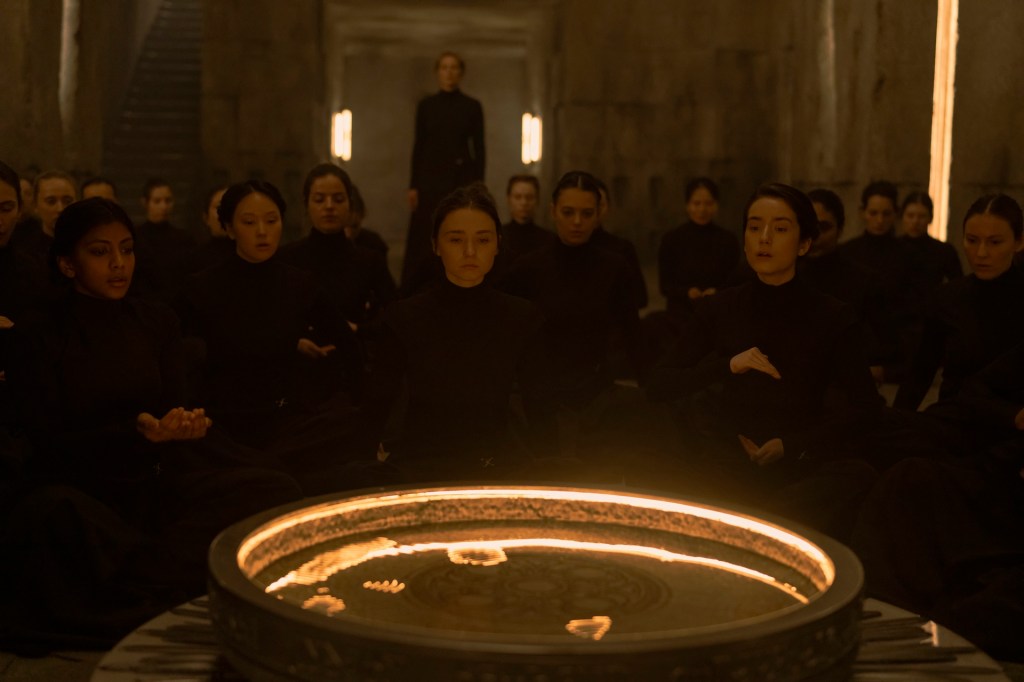 Dune: Prophecy still, several women seated around a pool of shiny golden water.