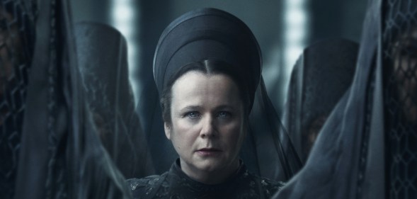 Emily Watson in Dune: Prophecy. She's sat in an all black dress and veil standing at the centre of several women with their dark veils conceiling their faces.