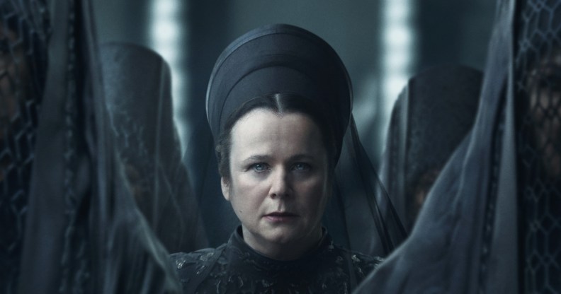 Emily Watson in Dune: Prophecy. She sits in an all-black dress and veil, standing in the center of several women with their dark veils concealing their faces.