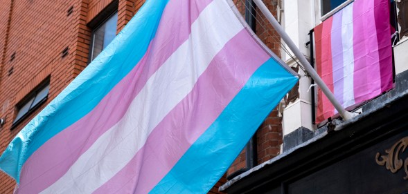 trans flag hanging outside of a building in Soho