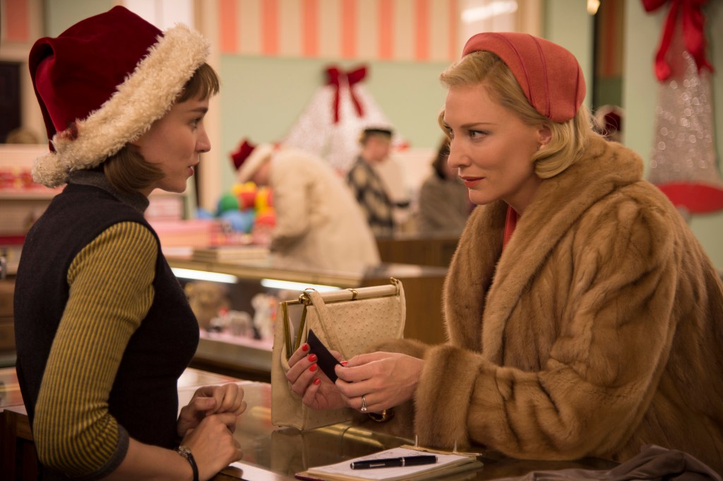 Rooney Mara and Cate Blanchett in Carol, the pair are wearing red hats in a department store