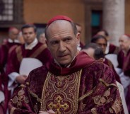 Ralph Fiennes in Conclave as Cardinal Thomas Lawrence in a red and gold robe.