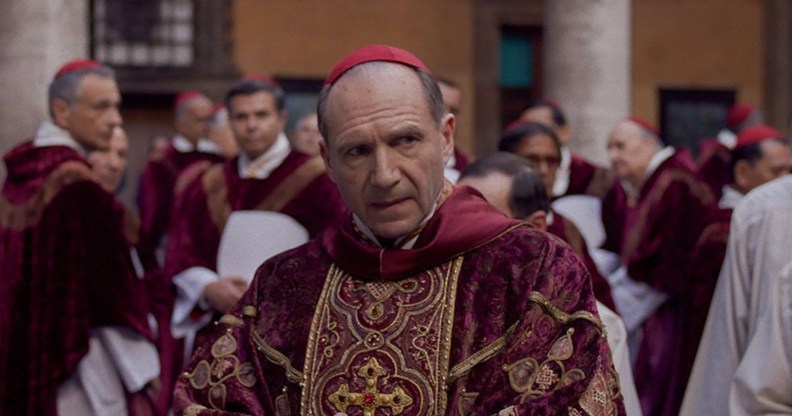 Ralph Fiennes in Conclave as Cardinal Thomas Lawrence in a red and gold robe.