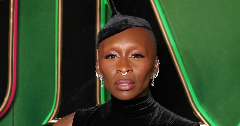 Cynthia Erivo attends the "Wicked: Part One" European Premiere . wearing dark green velvet dress and hat with multiple silver earings.