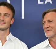 Drew Starkey and Daniel Craig on a red carpet looking away from the camera