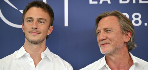 Drew Starkey and Daniel Craig on a red carpet looking away from the camera