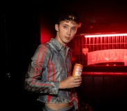 Troye Sivan holding a Smirnoff can.