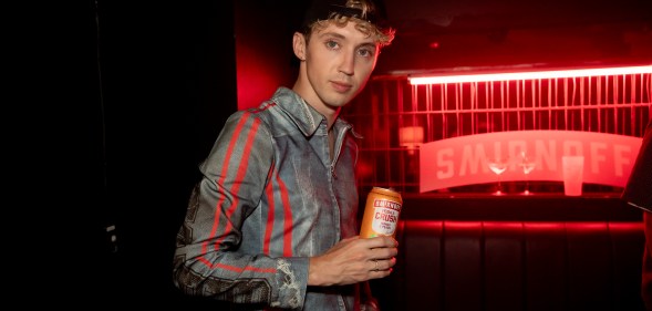 Troye Sivan holding a Smirnoff can.