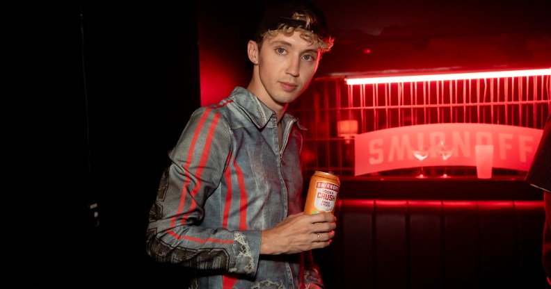 Troye Sivan holding a Smirnoff can.