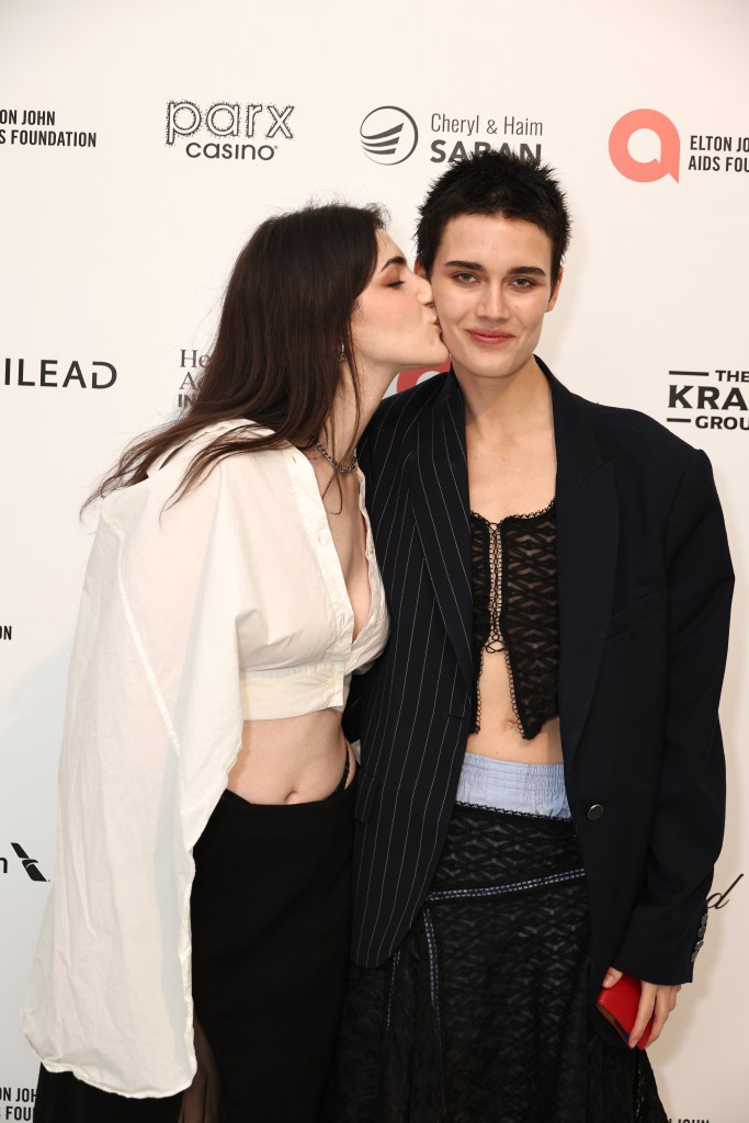 Kay and Juli Kocemba attend Elton John AIDS Foundation's 32nd Annual Academy Awards. THe pair are on the red carpet, Kay kissing Kocemba's cheek.