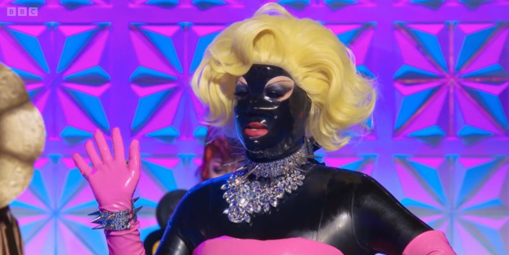 Lill dressed as a gimp suited version of Marilyn Monroe in Drag Race UK ep 9