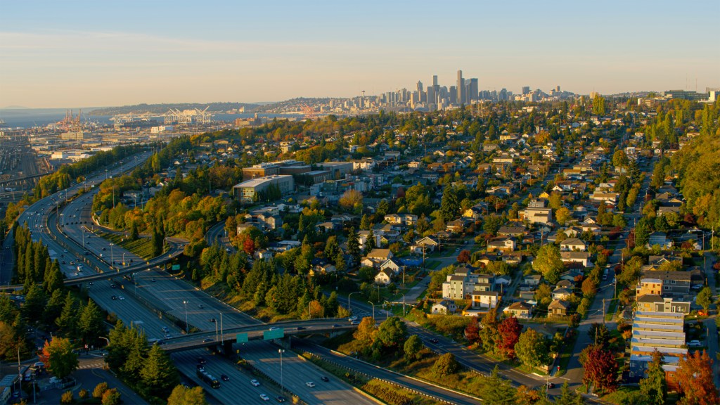 Aerial view of Seattle neighbourhood with downtown in distance against sky on sunny day, Seattle, Washington State, USA.