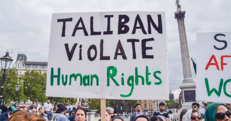 Person holds up a placard reading "Taliban violate human rights" at a protest against the Taliban in London