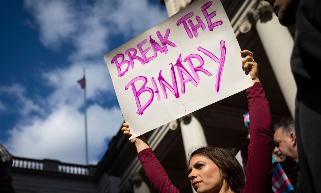 A person holding up a sign that reads "break the binary."