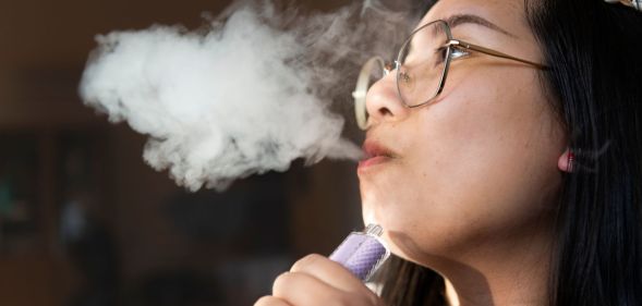 Stock image of a woman with a vape