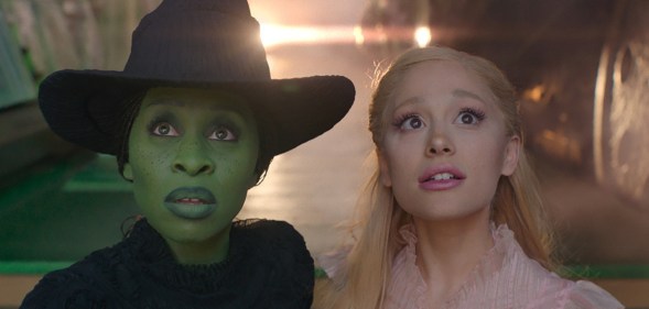 Cynthia Erivo as the green-skinned Elphaba and Ariana Grande as the pink-loving Glinda looking beyond the camera.