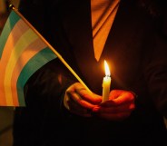 Trans Day of Remembrance Vigil, person holding a trans flag and a candle