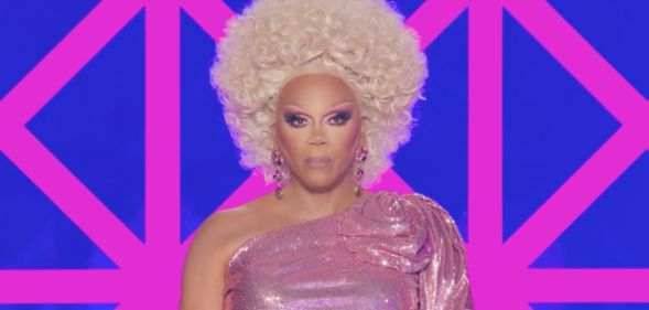 RuPaul in a pink dress with a stern face while hosting the final episode of drag race uk season 6