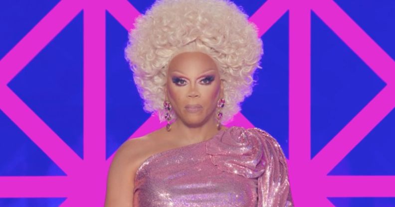 RuPaul in a pink dress with a stern face while hosting the final episode of drag race uk season 6