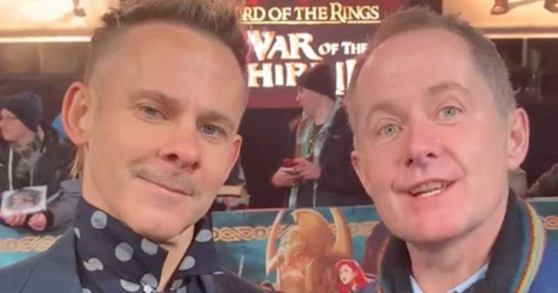 Lord of the Rings stars Dominic Monaghan and Billy Boyd stand next to each other as they smile intothe camera.