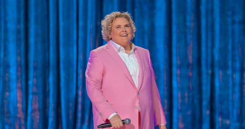 Fortune Feimster on stage in her Netflix special ‘Crushing It’ wearing a pink suit.