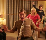 Gavin and Stacey still; family and friends surrounding Uncle Bryn (Rob Brydon) doing a limbo