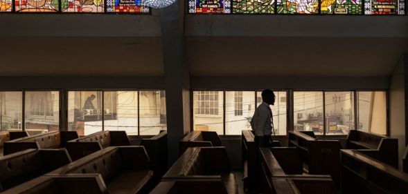 A man walks through the bench of the Methodist Church of the Trinity in Lagos on February 19, 2023 (Getty)