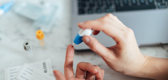 Someone performing a self-blood test on themselves.