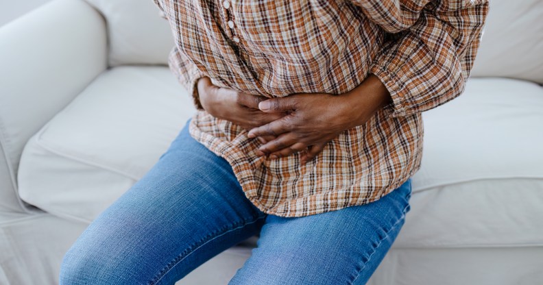 Person holding their abdomen in pain.