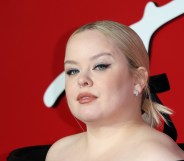 Nicola Coughlan attends The Fashion Awards , in a black open shoulder dress with her blonde hair tied back in a black bow