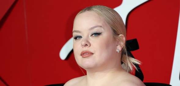 Nicola Coughlan attends The Fashion Awards , in a black open shoulder dress with her blonde hair tied back in a black bow