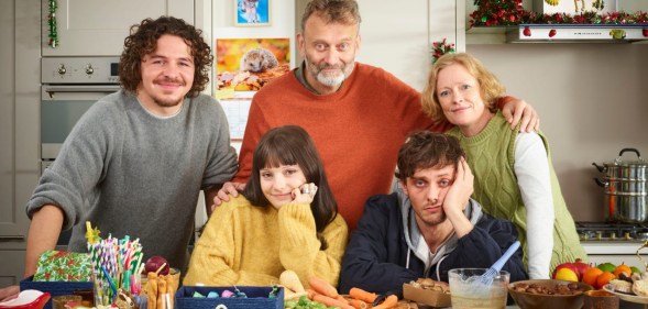 The Brockman family taking a family photo in the kitchen