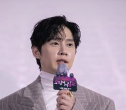 Park Sung-hoon attends Netfilx original series 'Squid Game: Season 2'. Wearing a white turtle neck and grey pinstripe suit