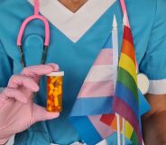 A doctor holding a trans flag, a Pride flag, and a capsule of pills.