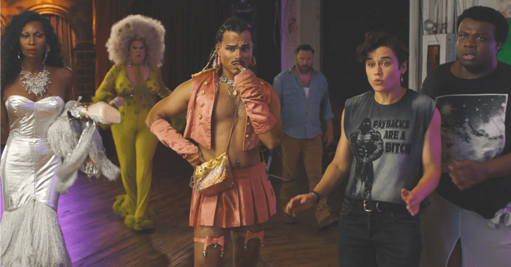 Queens of the Dead still: a few drag queens and folks looking at something scary off-screen.