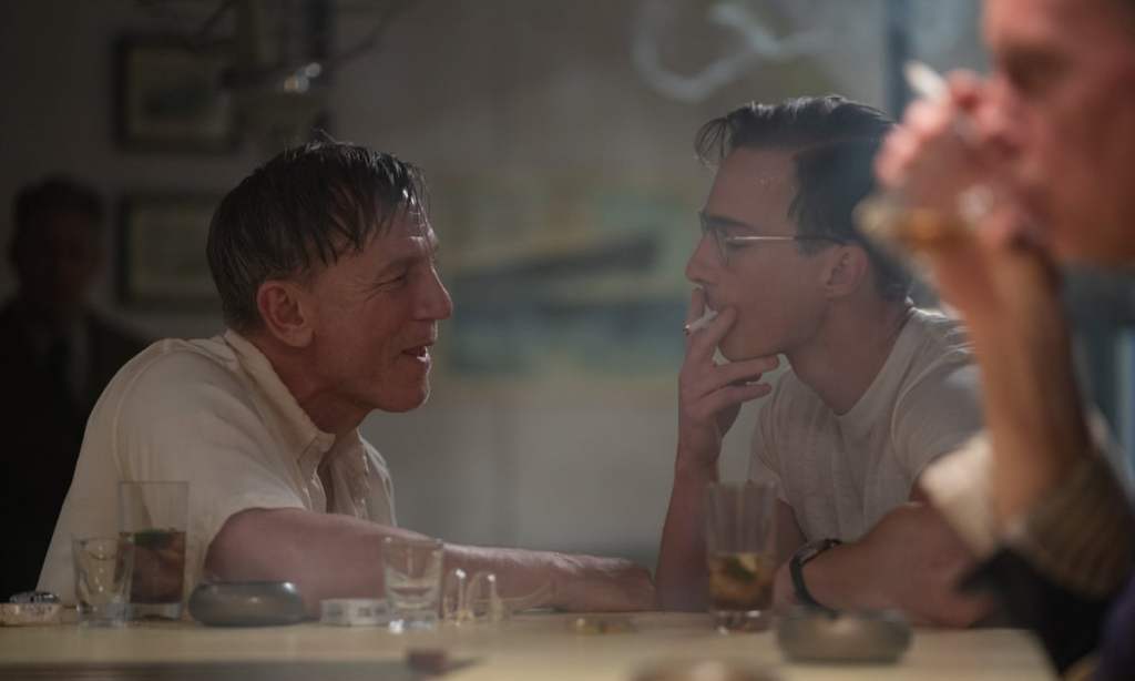 Queer still: Daniel Craig watching Drew Starkey smoke at a bar.