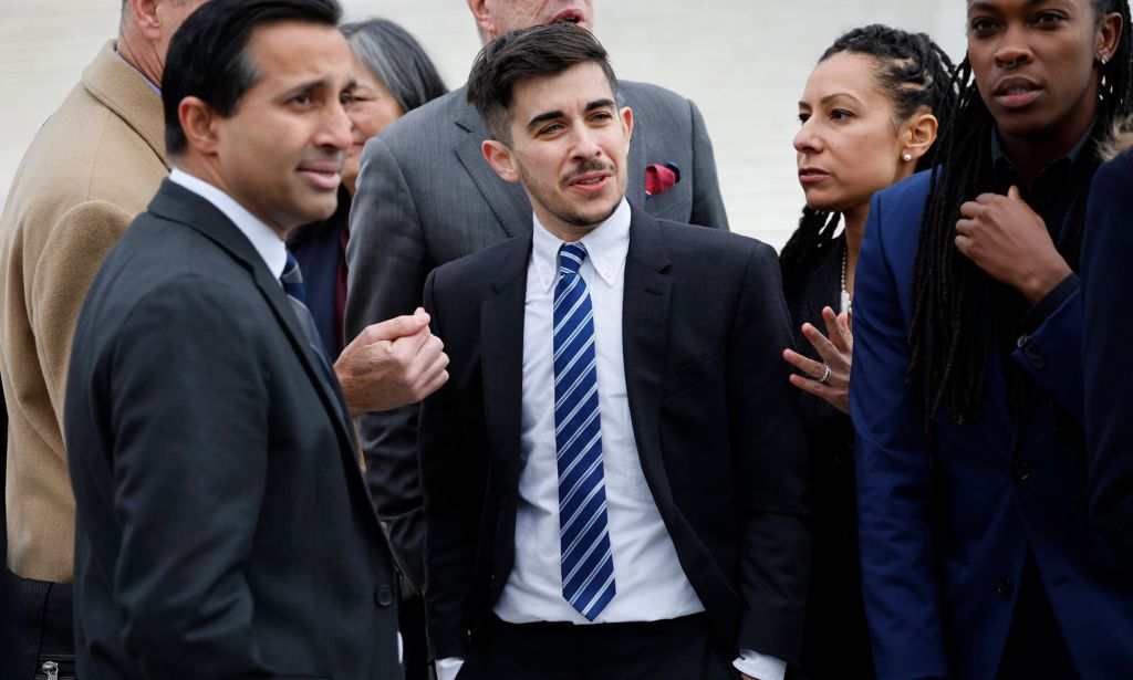 Several lawyers in suits standing around together.