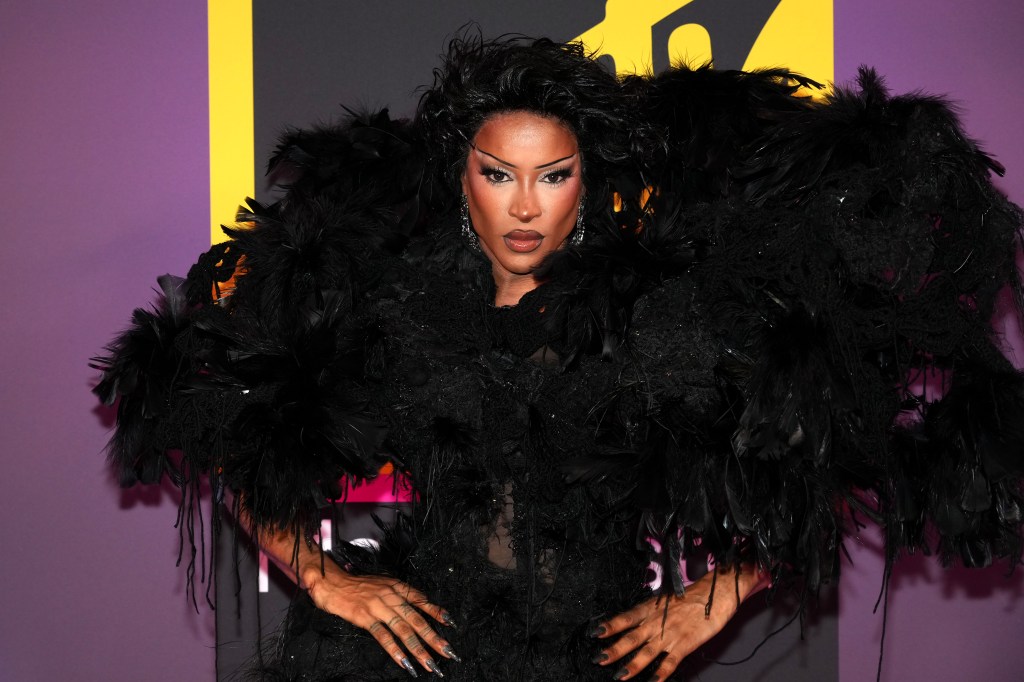 Tayce attends the MTV EMAs 2024. Dressed in a big black feathered shoulder piece.