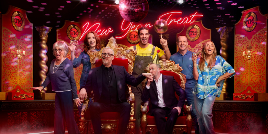 Taskmaster’s New Year’s Eve Treat promo image: judges Greg Davies and Alex Horn sat on thrones while contestants (Sue Johnston, Hannah Fry, David James, Martin Lewis, Melanie Blatt) are around them.