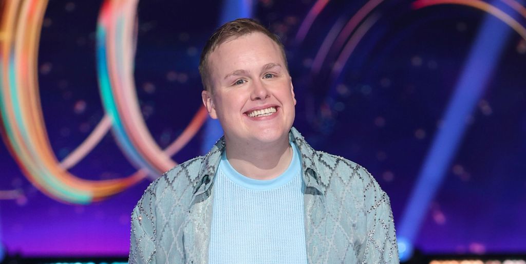 Josh Jones in a blue t-shirt and blue overshirt, smiling during a photo call for Dancing On Ice