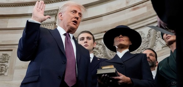 Donald Trump is sworn in as US president by Supreme Court Chief Justice John Roberts during inauguration ceremonies in the Rotunda of the Capitol on January 20, 2025 in Washington, DC, as his wife Melania Trump and son Barron Trump look on. Trump takes office for his second non-consecutive term as the 47th president of the United States. (Photo by Morry Gash / POOL / AFP)