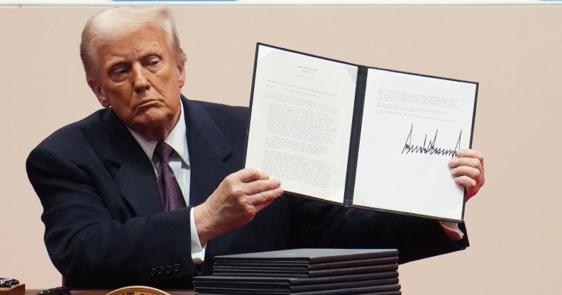 US President Donald Trump holds up an executive order after signing it during an indoor inauguration parade at Capital One Arena on January 20 2025 in Washington, DC